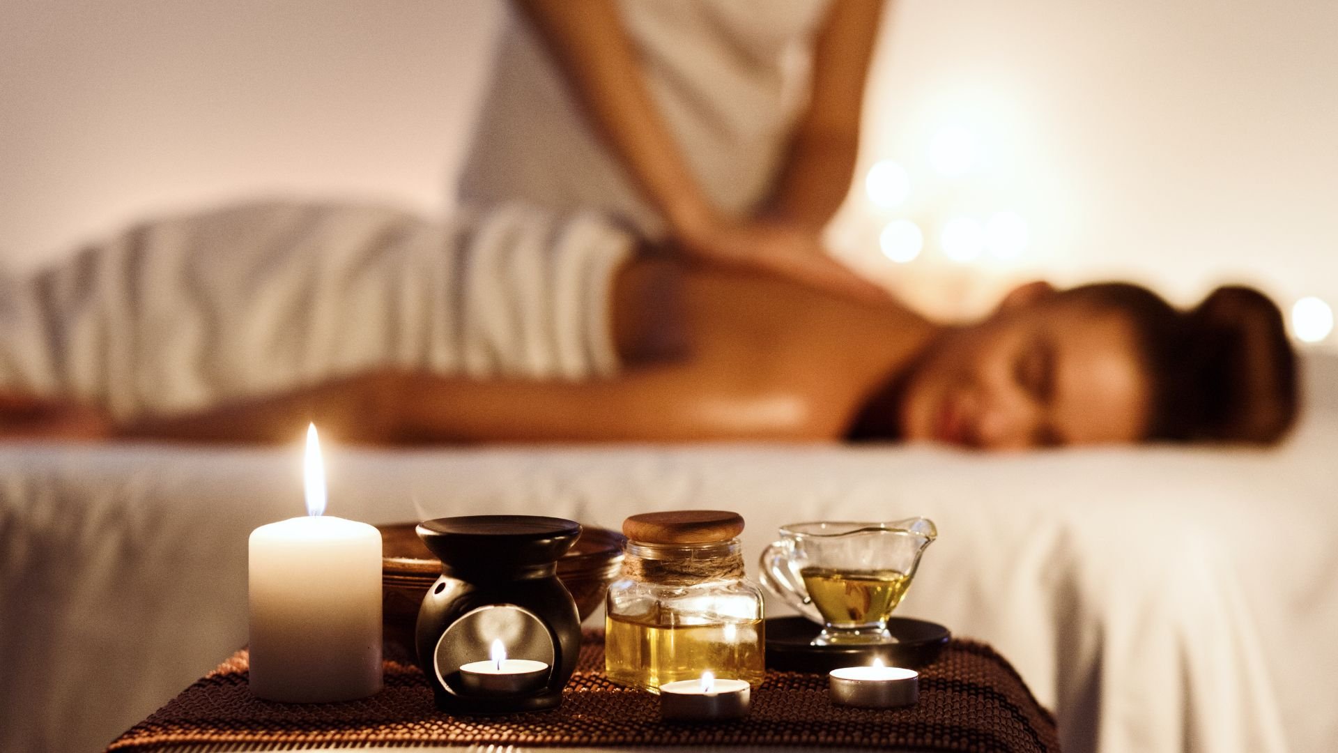 Spa massage setting with candles, essential oils, and relaxing massage table