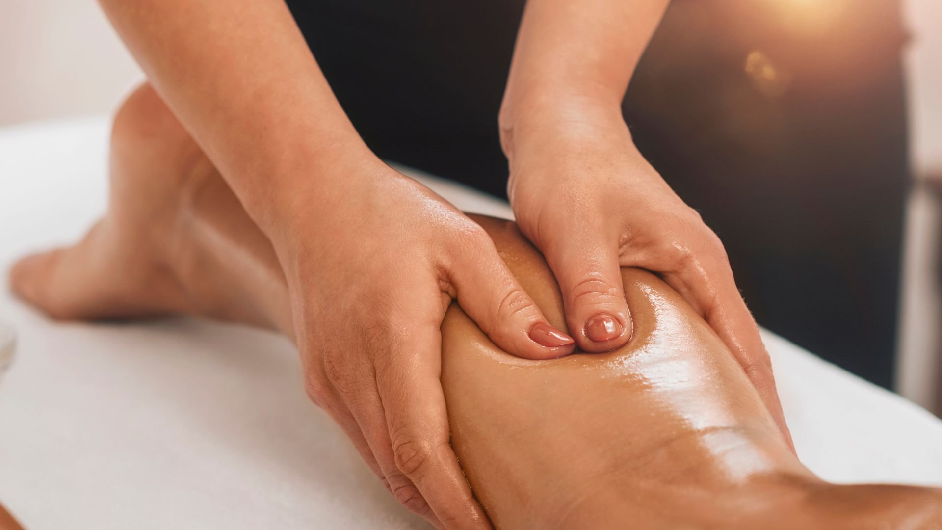 Hands massaging an oiled leg during a relaxing therapeutic massage