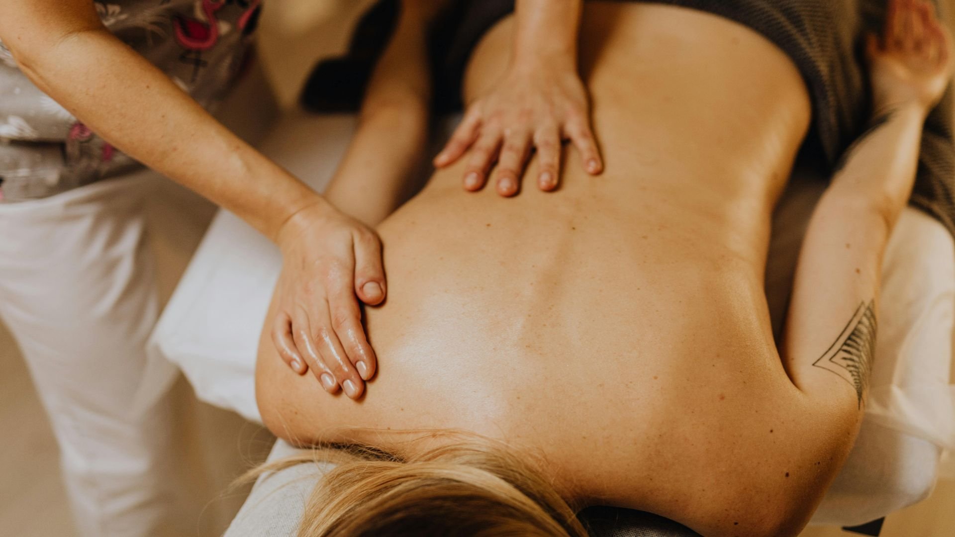 Massage therapist applying pressure during a back massage treatment